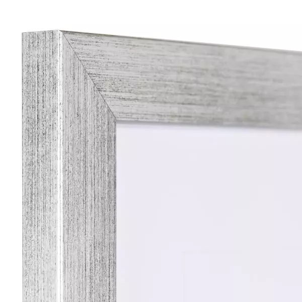 Ansicht der Ecke eines silbernen Bilderrahmens mit sichtbarer Holzstruktur, glatter Oberfläche und kantigem, schlichtem Profil